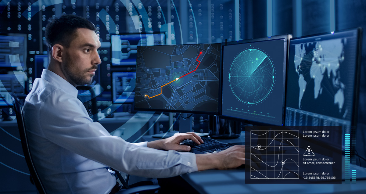 Man sitting in front of two monitors display maps and sonar.